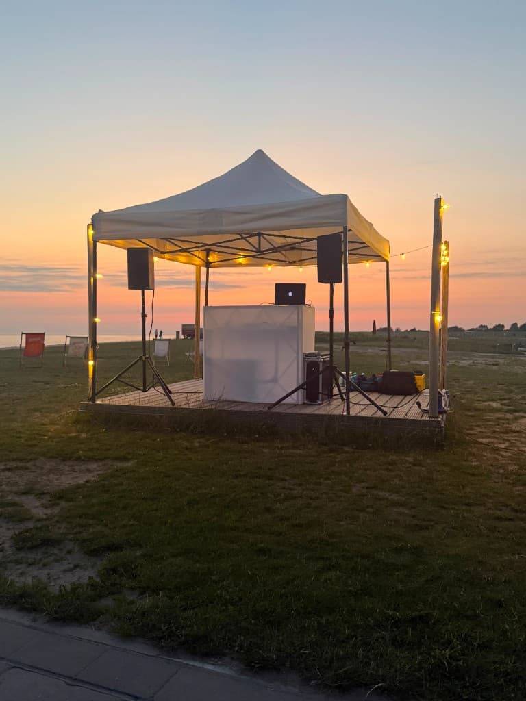 Mobiler Outdoor-DJ mit Technik bei Sonnenuntergang
